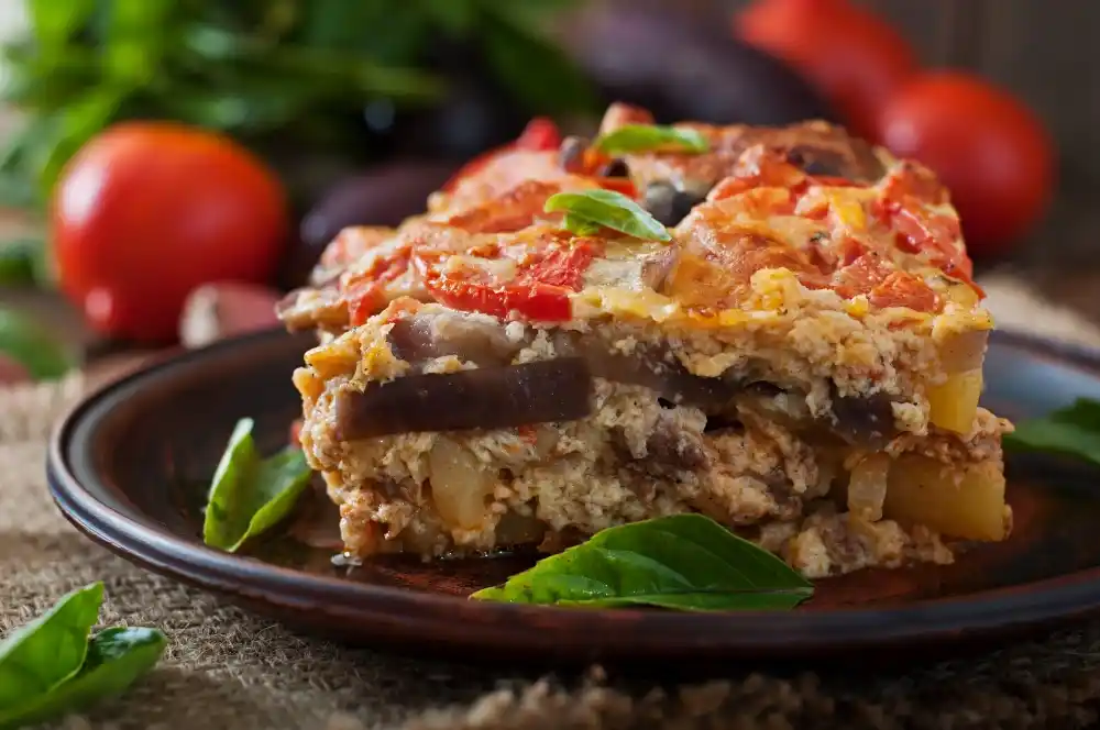 Traditional Greek moussaka with layers of aubergine, meat and béchamel served on a plate.