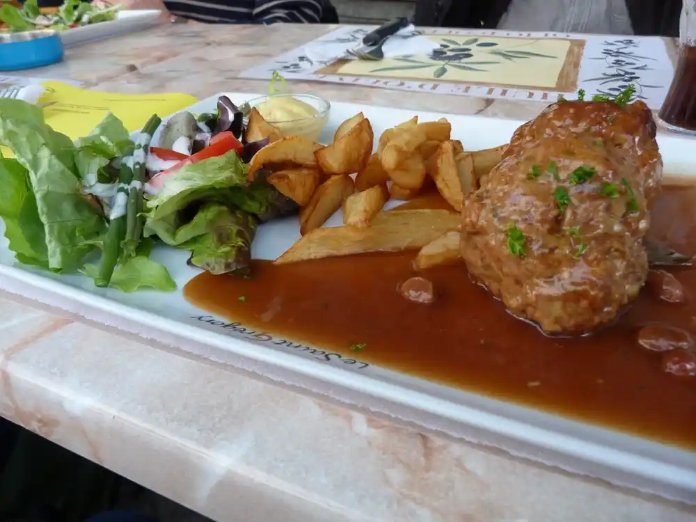 Hidangan boulets à la Liégeoise dengan kentang goreng dan saus.