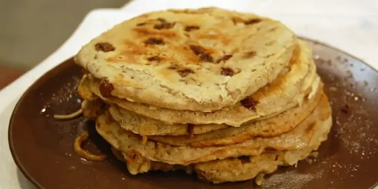 Boûkètes, traditional Liège buckwheat pancakes with raisins, stacked on a plate.