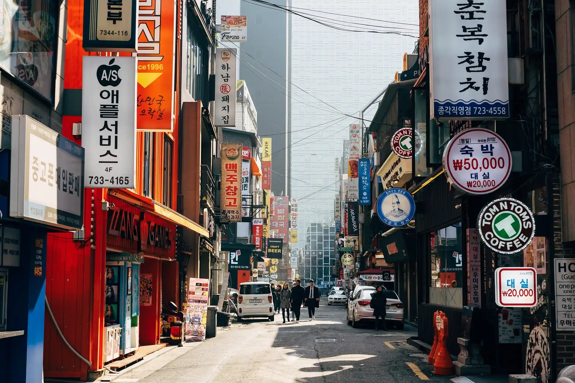 Jalan di Seoul dengan kafe, toko dan papan tanda Korea berwarna.